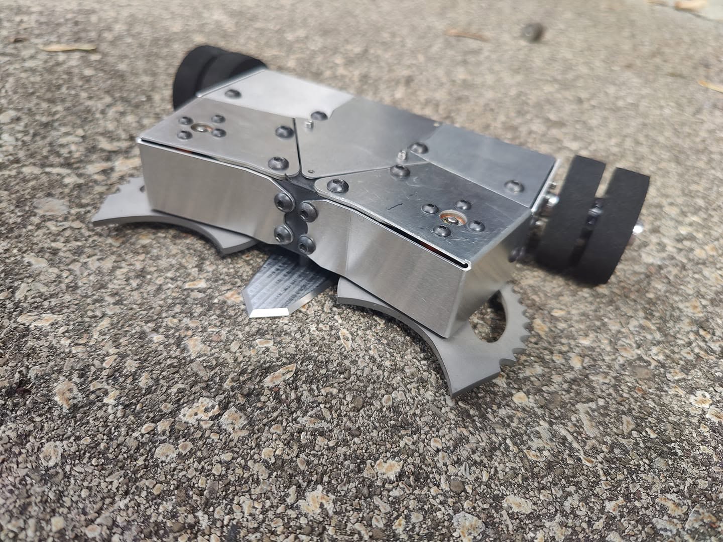 Polished stainless steel combat robot wedge on pavement