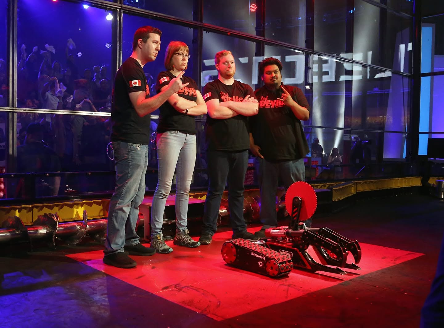 Team Red Devil on the BattleBots TV show stage with their robot under dramatic red lighting